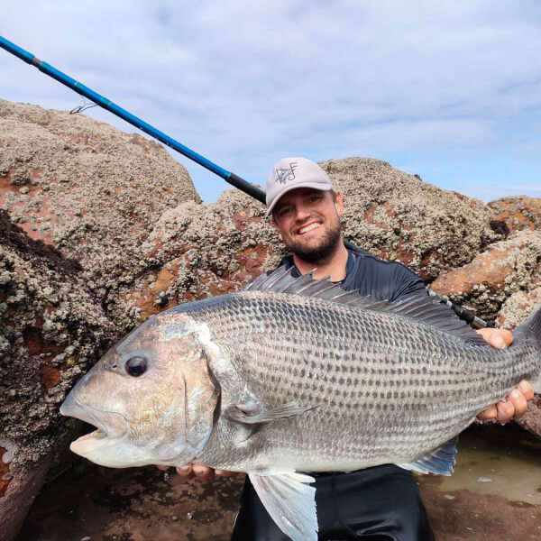 Things to do in Jeffreys Bay, Duvan Fishing. Man holds massive fish.